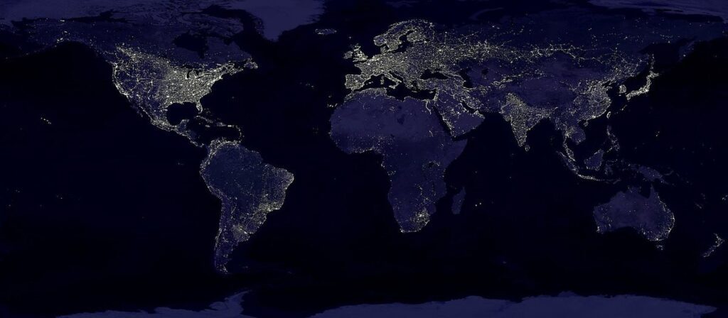World map of city lights at night from satellite data, showing where electricity and development are concentrated across the continents