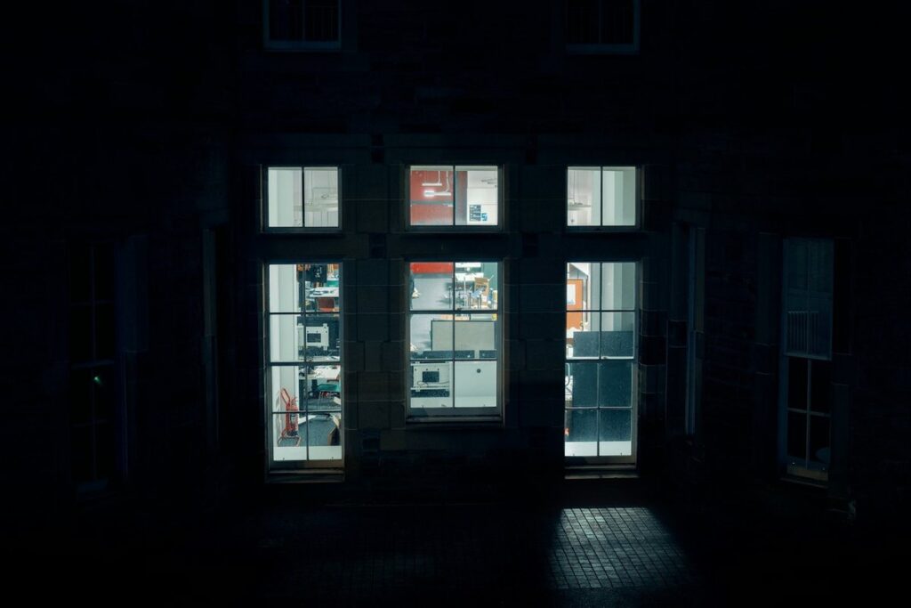 Lit office windows in a dark building late at night
