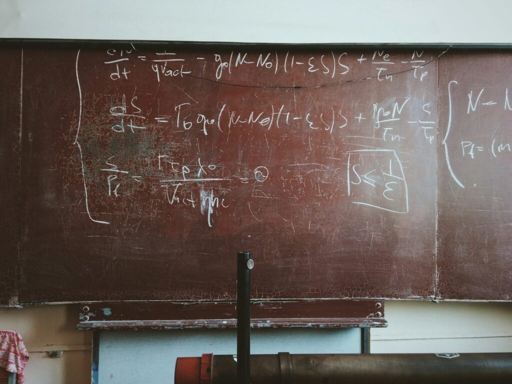 Physics equations chalked on a worn blackboard in an old lecture room
