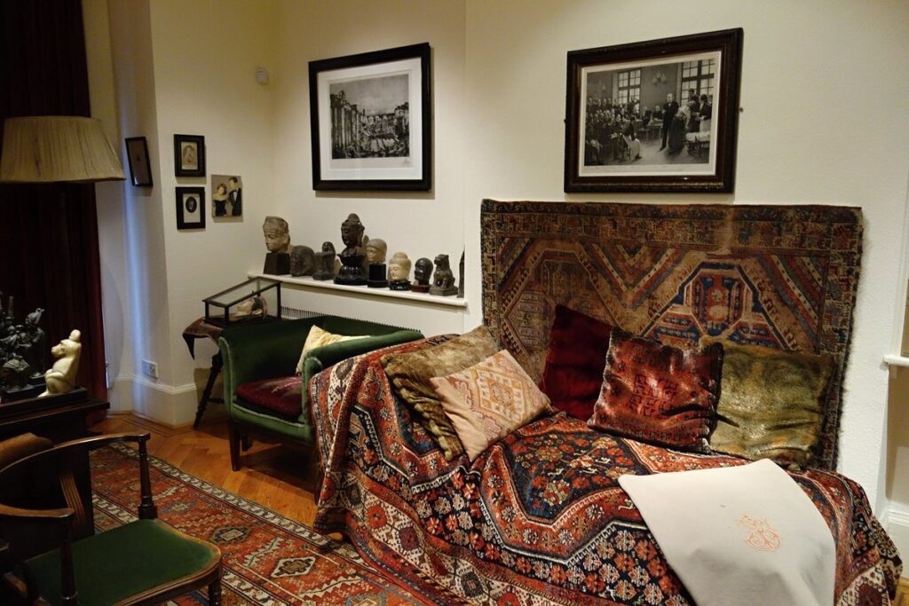 Sigmund Freud's analytic couch draped in Persian rugs in his study at the Freud Museum, London