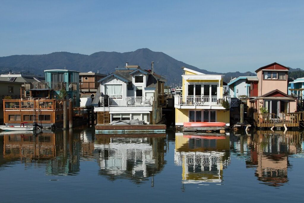 Colorful floating homes in the Sausalito houseboat community reflected in calm water, with Mount Tamalpais behind