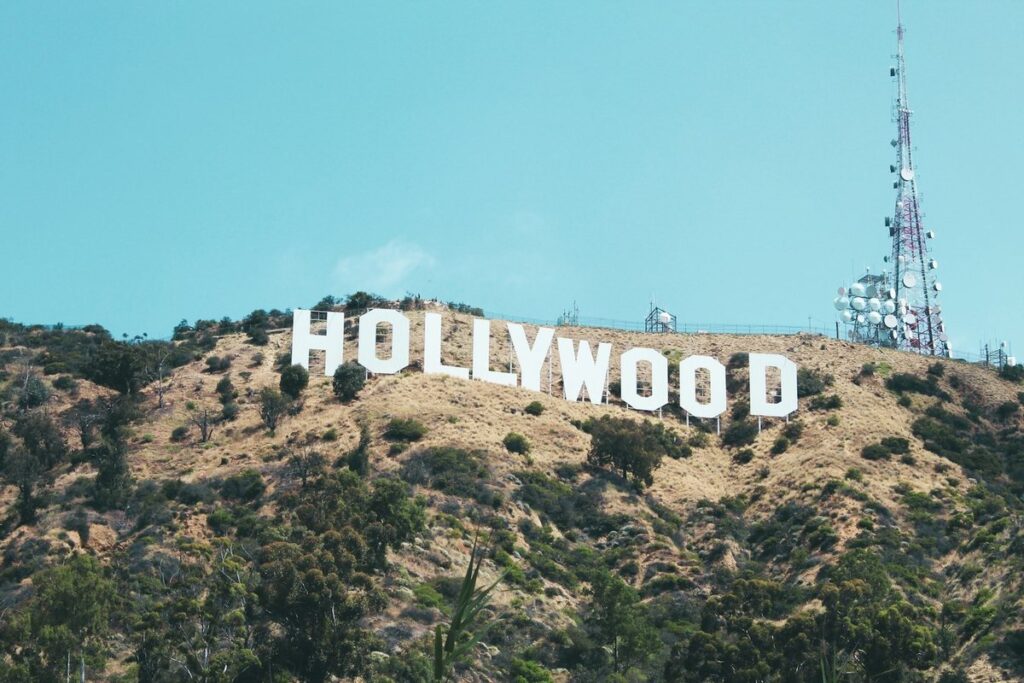 The Hollywood sign on a scrubby hillside above Los Angeles under a clear blue sky